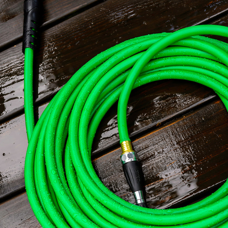 A coiled up green hose on a wooden deck