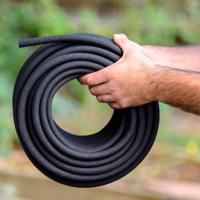 Close up of hands holding a rolled up soaker hose