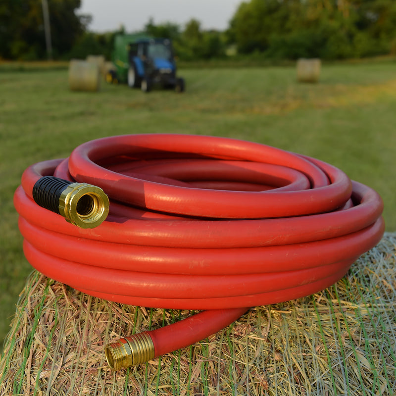 A red hose rolled up and sitting on a hay bale