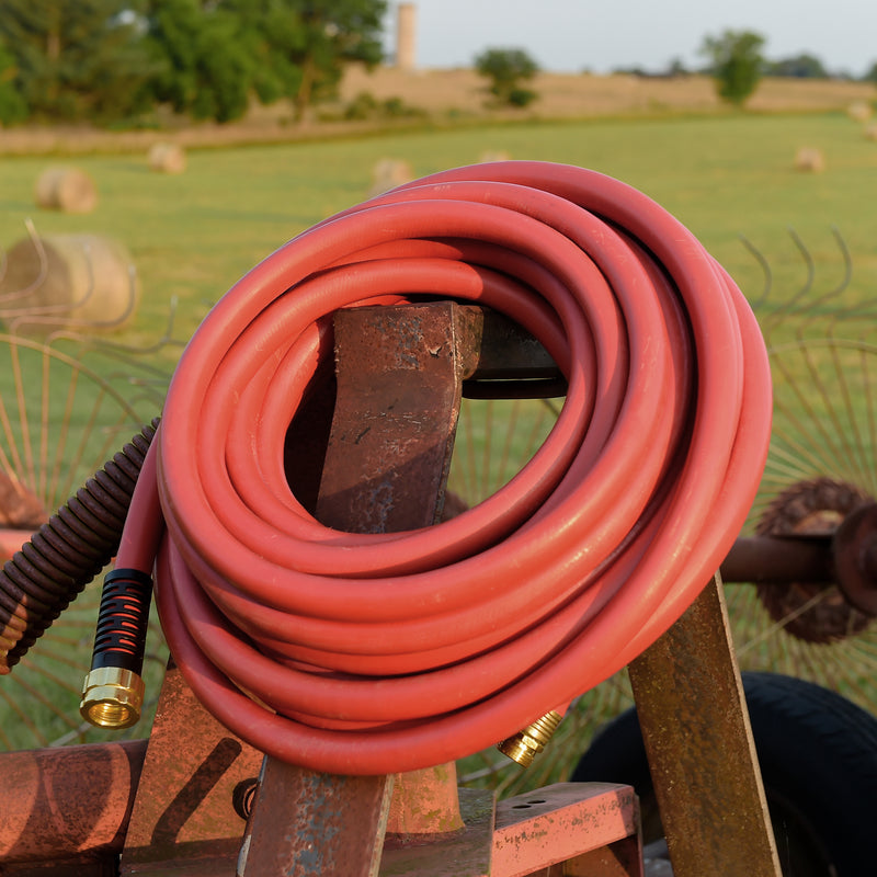 A red hose rolled up and hanging at a farm