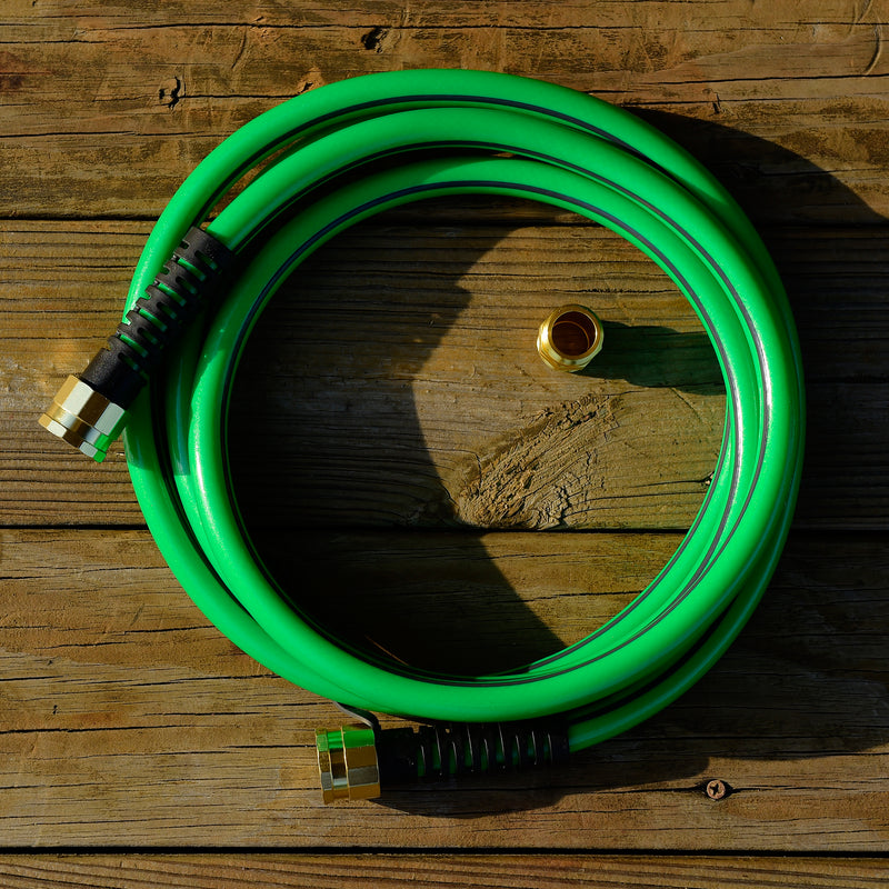 Green hose with metal fittings on a deck