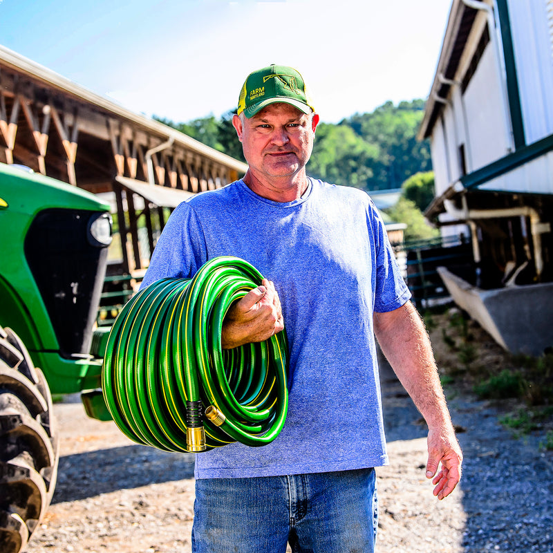 Man holding a John Deere hose wrapped around his arm