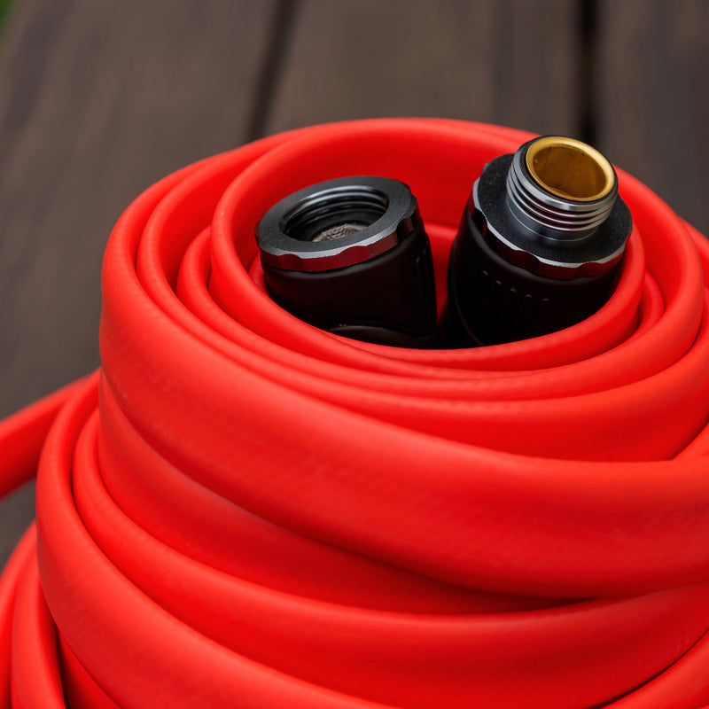 Close up of a coiled up red hose with black couplings