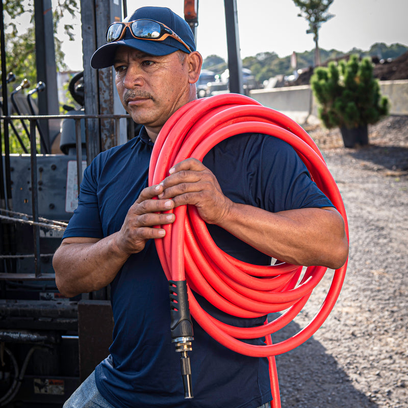 A man carrying a coiled up red hose