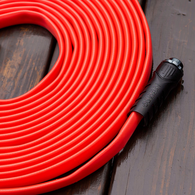 A coiled up red hose showing a black connector