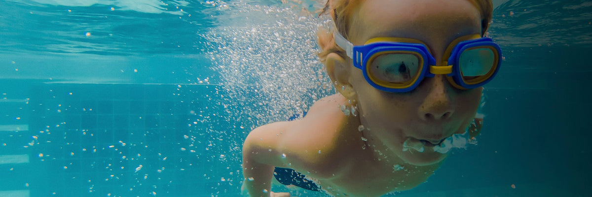 Child wearing goggles while swimming underwater