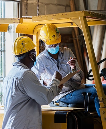 Two construction workers signing paperwork