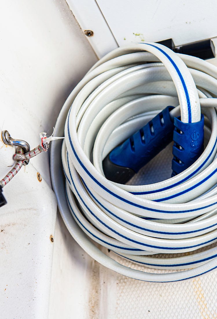 Coiled up white and blue hose on a boat