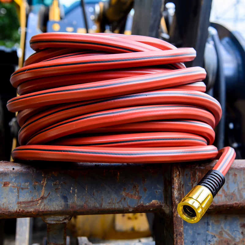 A red hose wrapped up and sitting on farm equipment