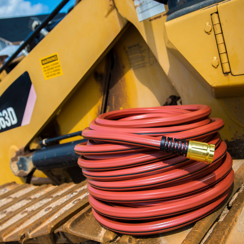 A red hose wrapped up and sitting on construction equipment