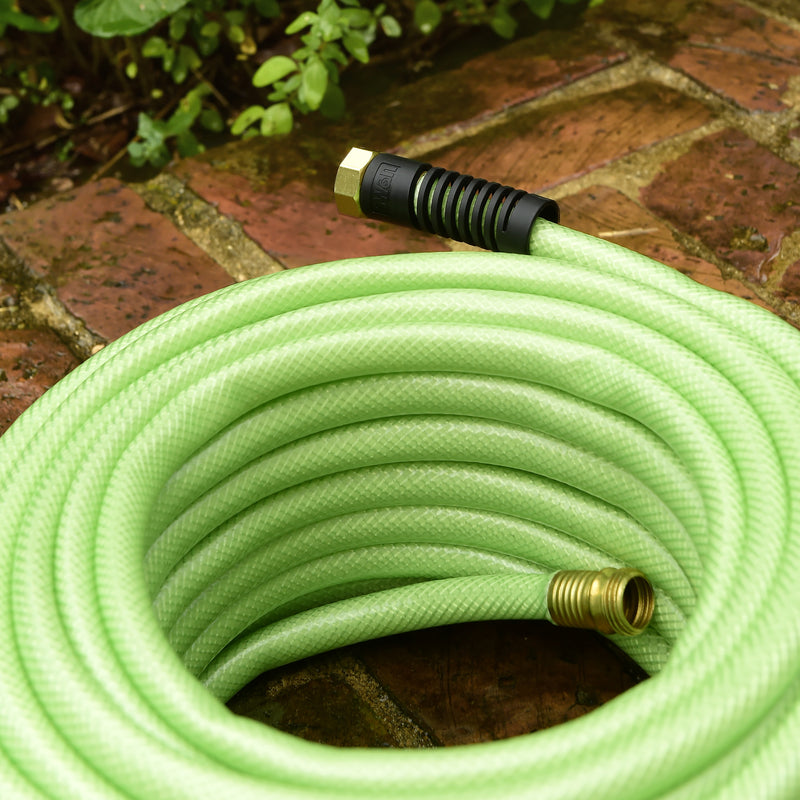 A light green hose coiled up on patio stones