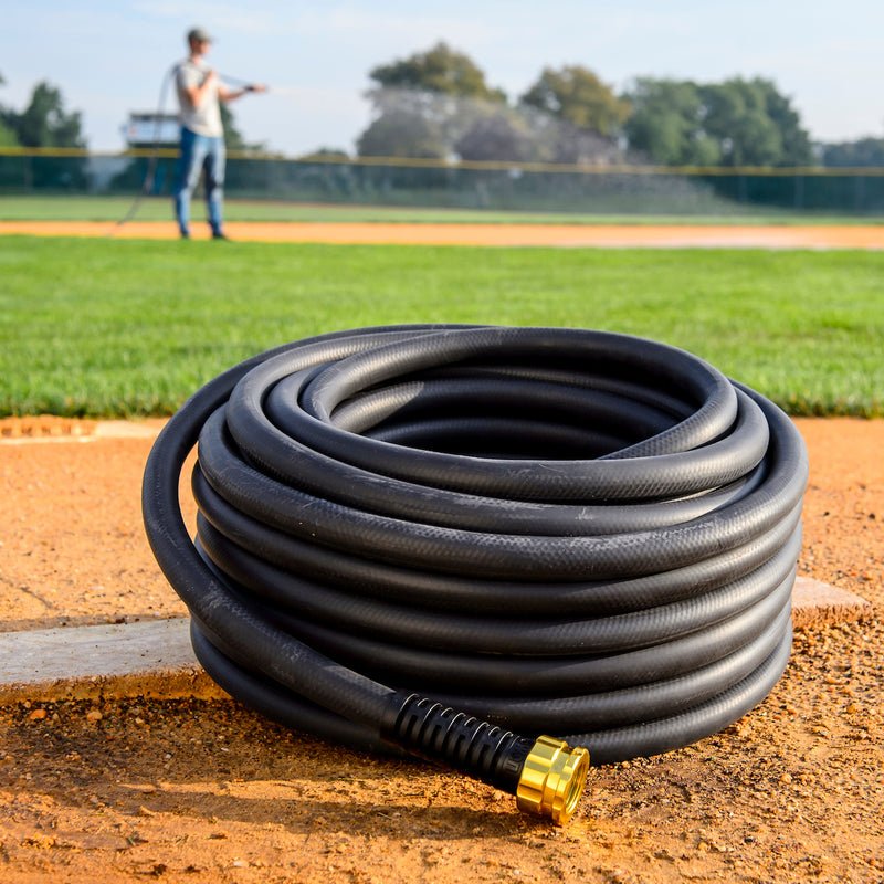 Black hose coiled up on a sports field