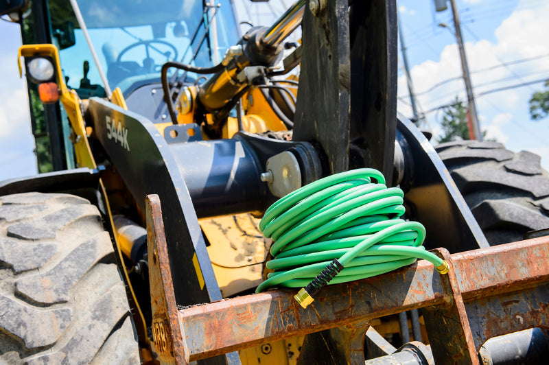 A coiled green hose on construction equipment