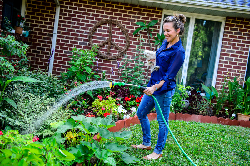 A woman watering a garden at home