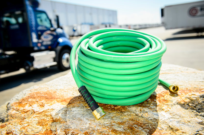A coiled green hose at an outdoor job site