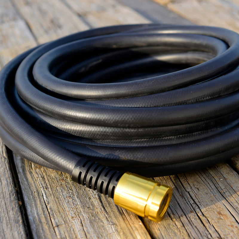 Coiled up black rubber hose on a wooden deck