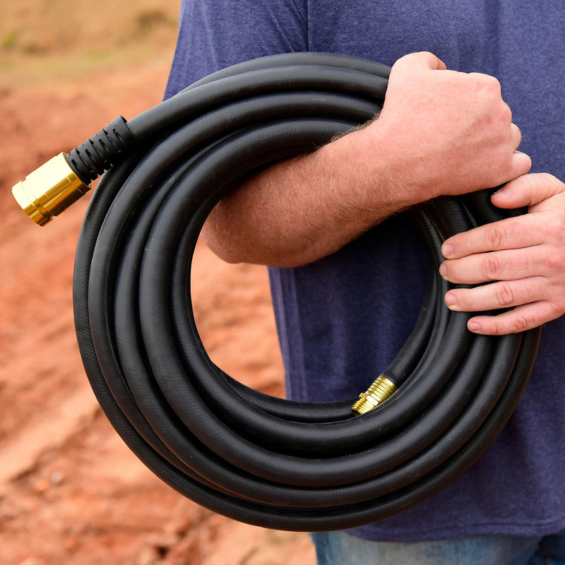 Man holding a black rubber hose around his forearm