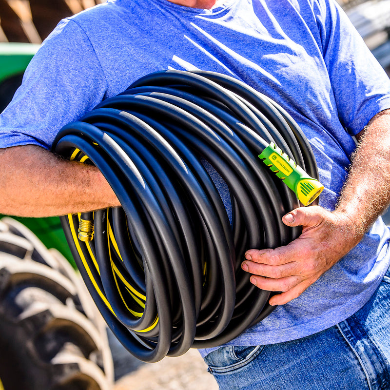 Man holding a rolled up rubber hose