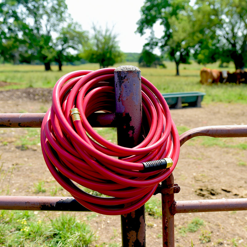 Heavy Duty Farm & Ranch hose coiled and hanging on a fence